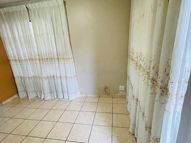 A functional kitchen area featuring tiled flooring, a built-in oven, and a wall-mounted security alarm keypad.