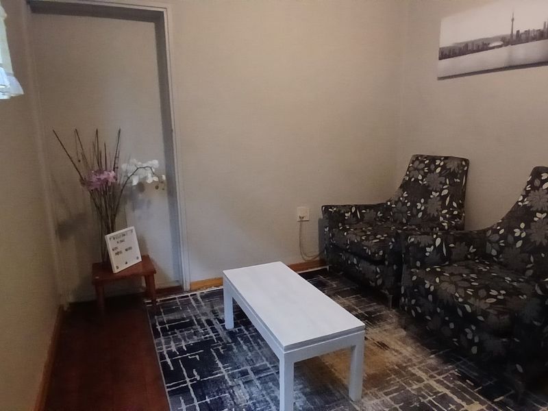 A simple living room area featuring wooden flooring and neutral wall finishes.