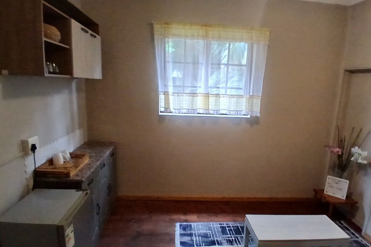 A compact kitchen area featuring built-in cabinetry, laminate countertops, and a window with natural light.