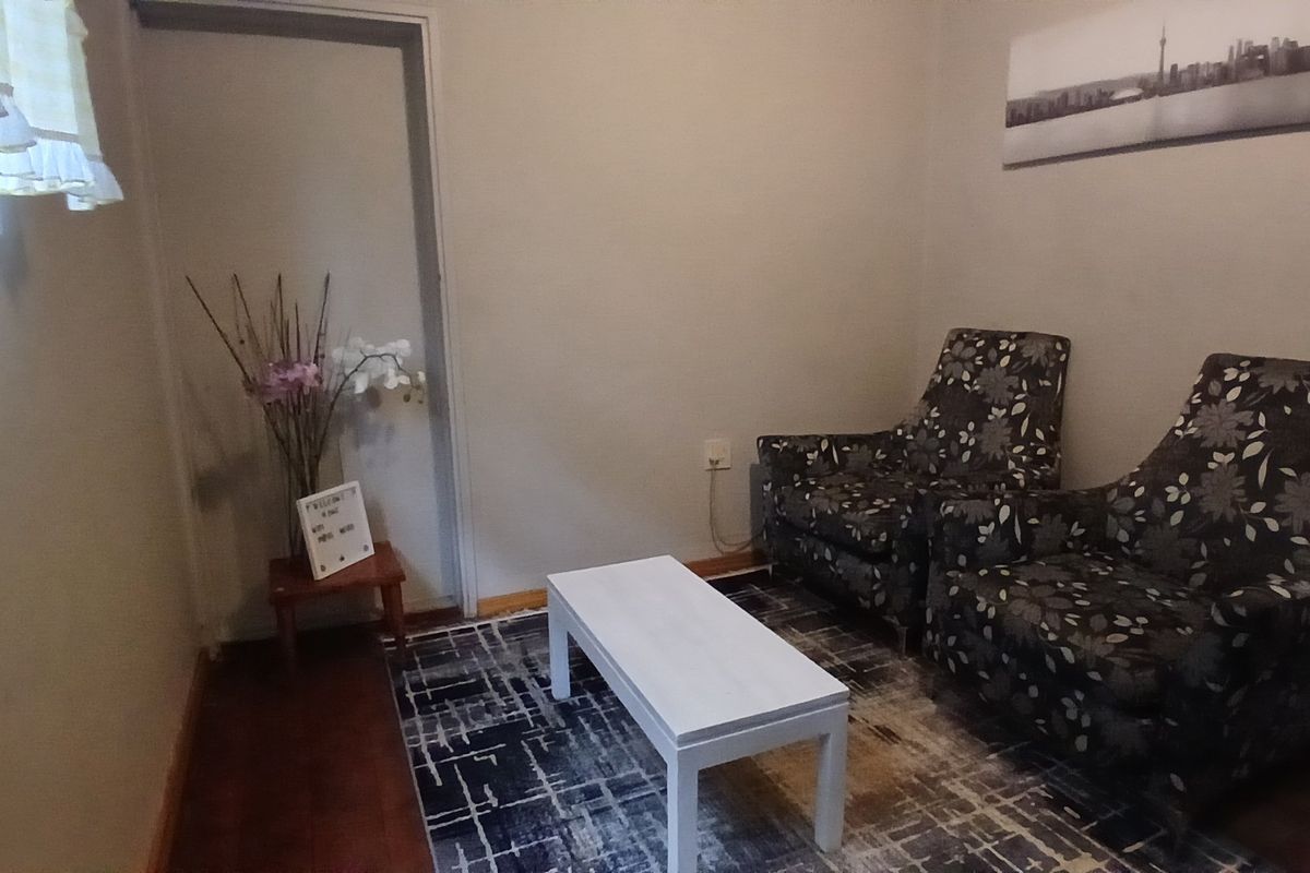 A simple living room area featuring wooden flooring and neutral wall finishes.