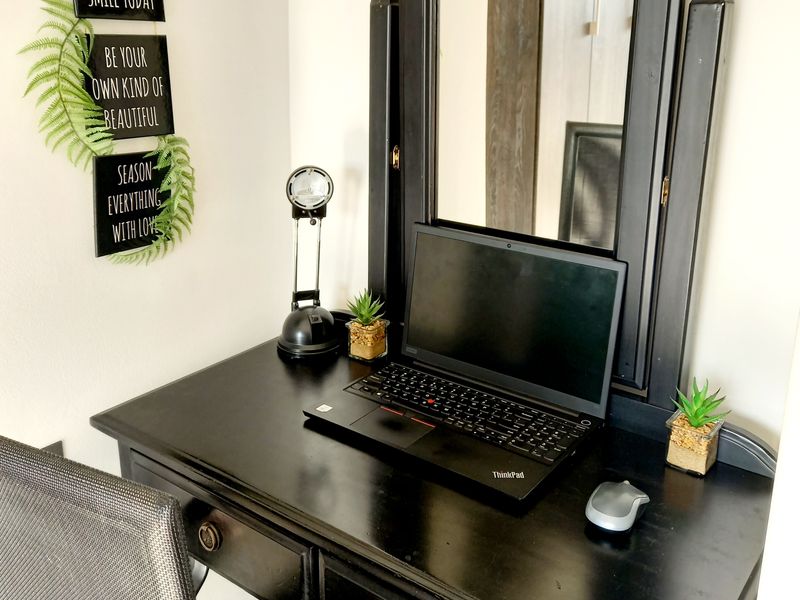 A compact home office workspace featuring a built-in desk area with a mirror, suitable for remote work or study.