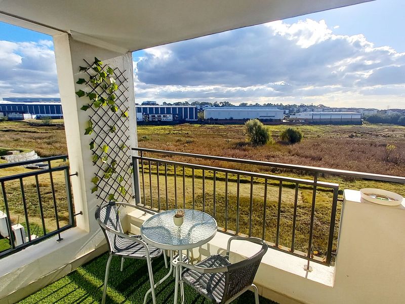 A covered balcony featuring a metal balustrade and open views over the surrounding landscape.