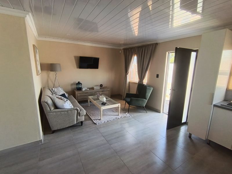 Open plan living area featuring tiled flooring, tongue and groove ceiling, and direct access to the exterior.