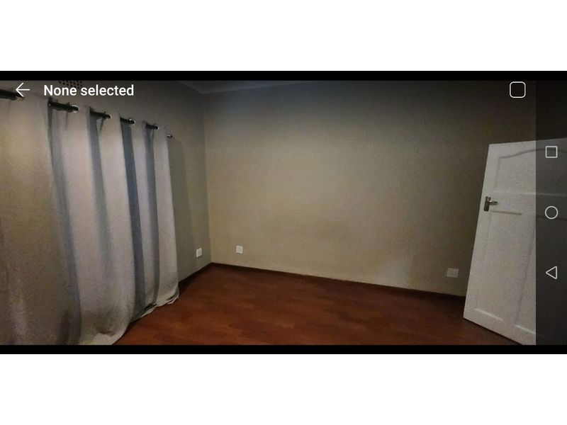 An empty bedroom featuring laminate flooring and neutral wall finishes, providing a blank canvas for personalization.
