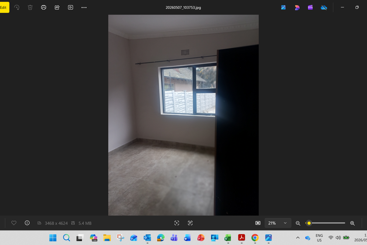 A vacant bedroom featuring tiled flooring, a window with a curtain rod, and crown molding.