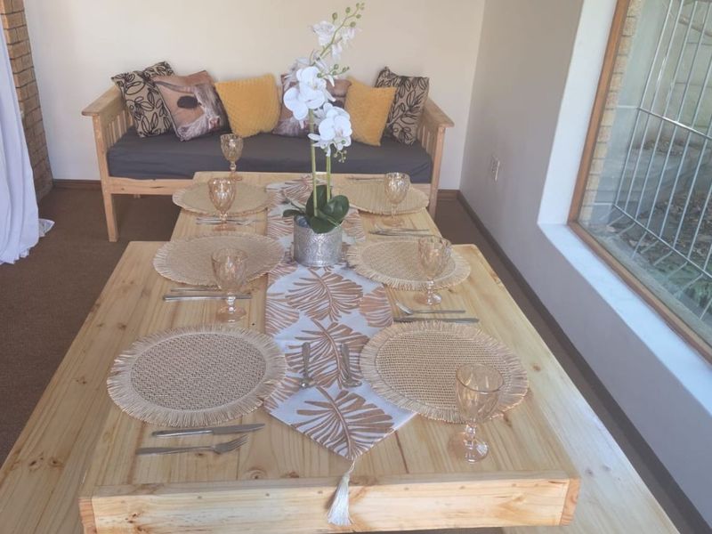 A dining area featuring a large wooden table and a brick feature wall, providing a rustic and functional space for meals.