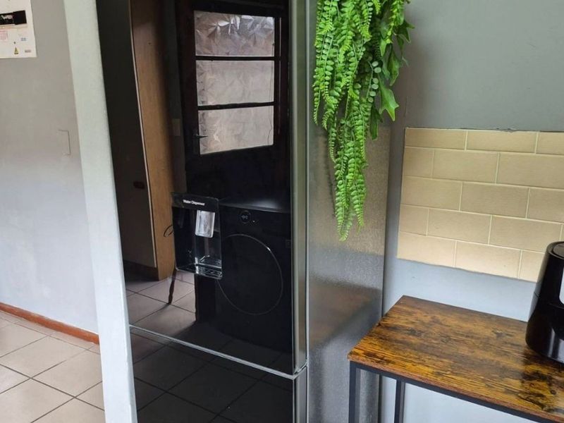 A kitchen area featuring tiled flooring and a neutral subway tile backsplash, providing a functional space for food preparation.