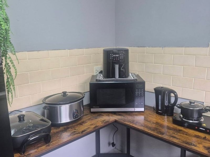 A compact kitchen corner featuring a subway tile backsplash and wood-look laminate countertops, providing a functional prep area.