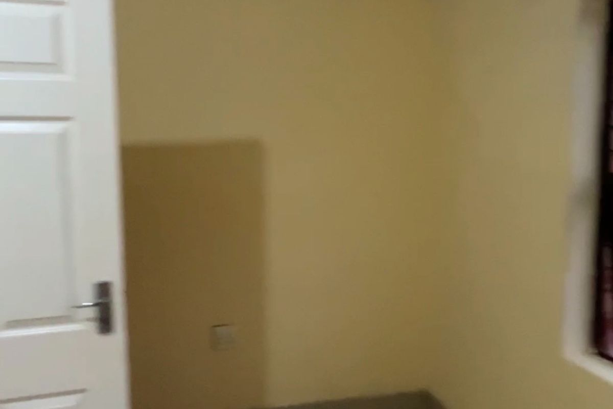 An empty bedroom featuring neutral wall paint, coving, and tiled flooring, providing a blank canvas for personalization.