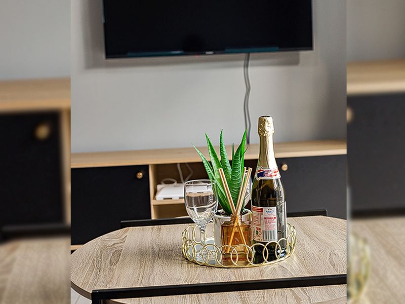 A modern living area featuring a wall-mounted television and sleek built-in cabinetry with a contemporary finish.