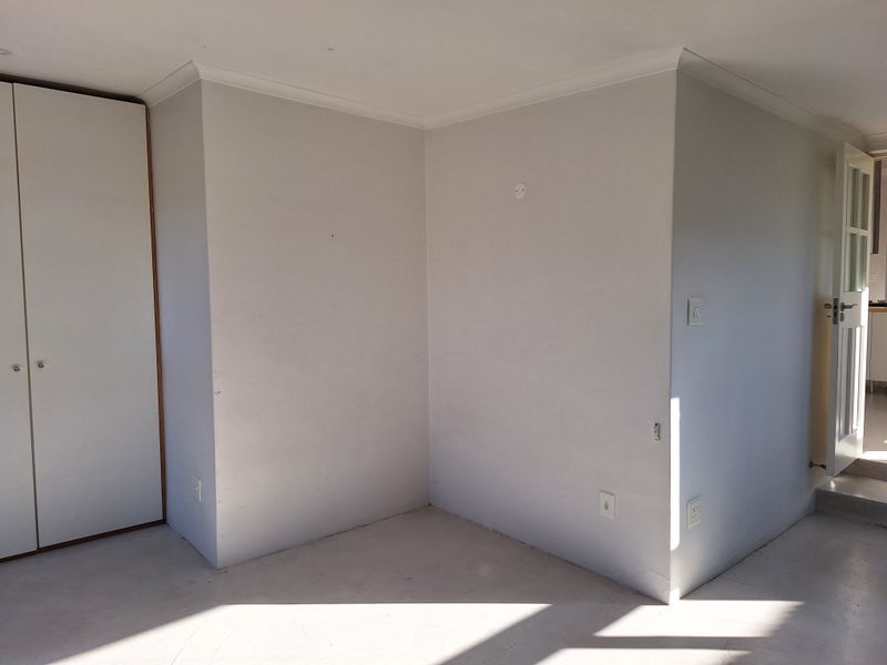 An empty bedroom featuring built-in cupboards, neutral walls, and coving, offering a blank canvas for personalization.