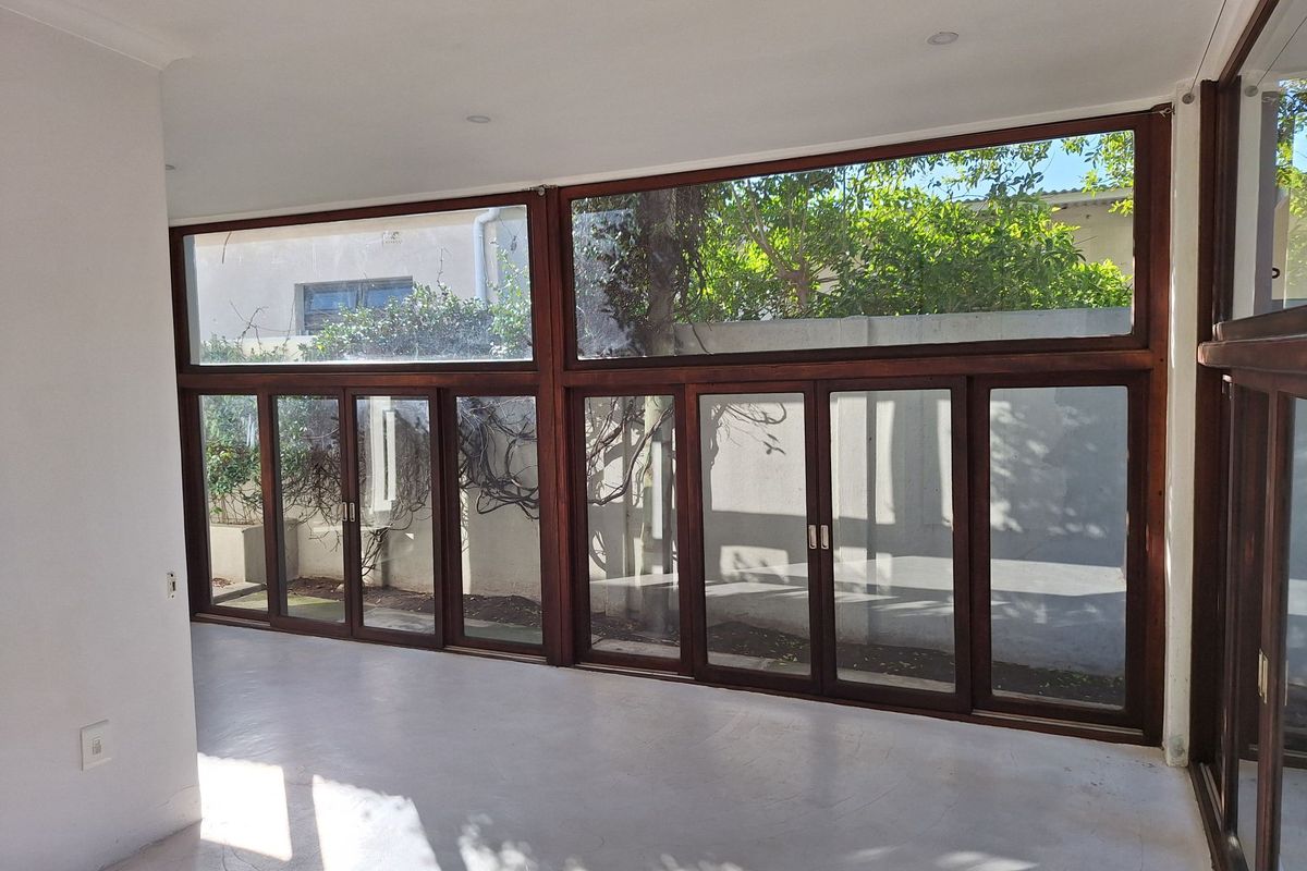 Bright and spacious living area featuring polished concrete floors and expansive timber-framed folding glass doors that open to the garden.
