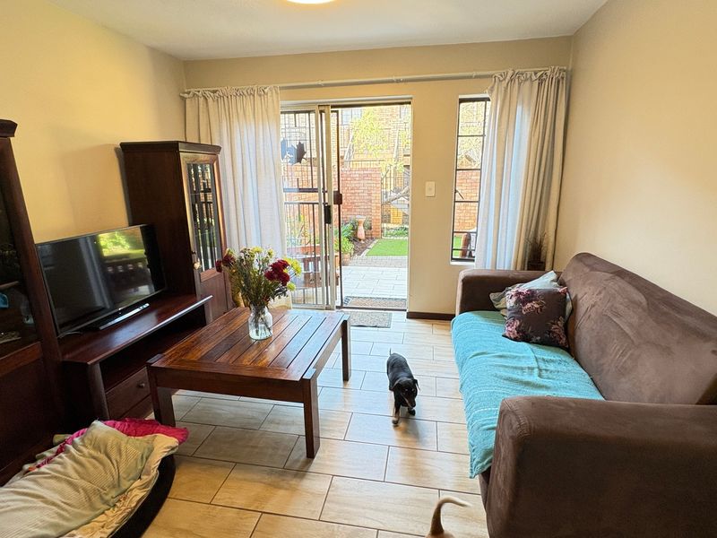 A living room featuring tiled flooring and a sliding glass door providing access to an outdoor patio area.
