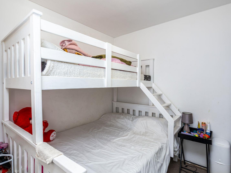 A functional bedroom featuring a built-in bunk bed configuration with neutral wall finishes.