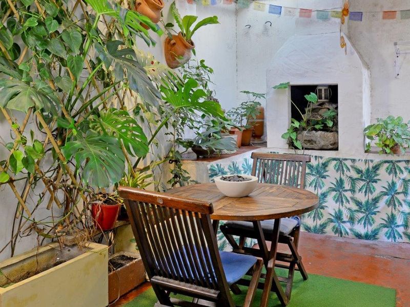 A rustic outdoor patio area featuring a built-in masonry fireplace and concrete flooring, offering a cozy space for outdoor relaxation.