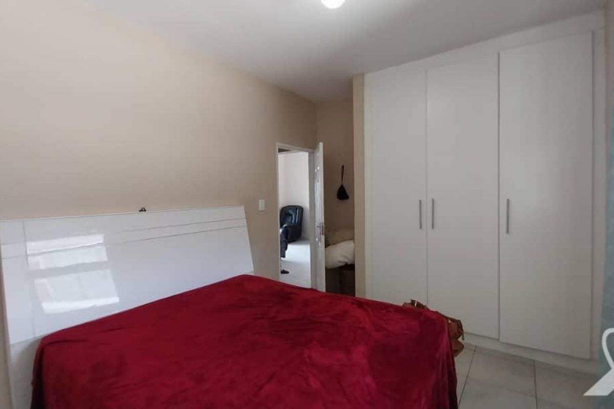 A well-maintained bedroom featuring built-in white cabinetry and tiled flooring, offering a clean and functional living space.