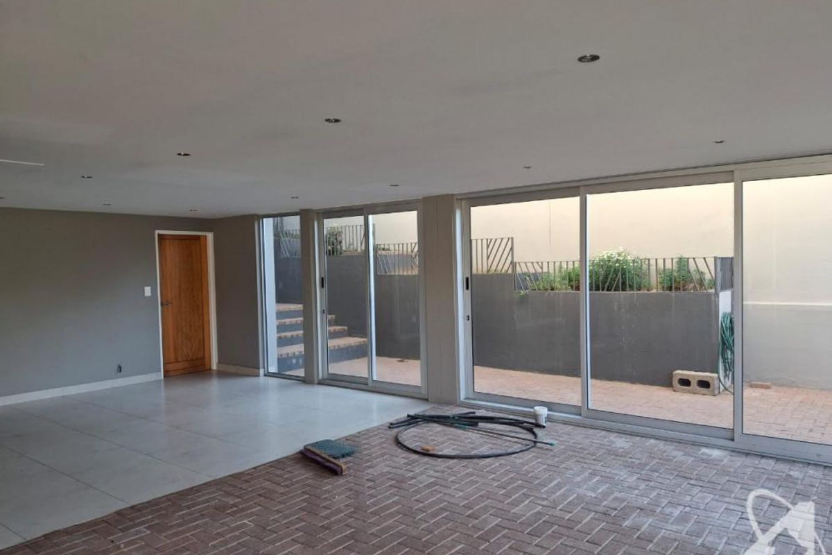 Spacious open-plan living area featuring large sliding glass doors that provide seamless access to the outdoor patio and garden area.