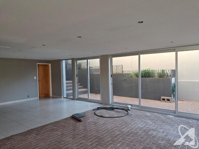 Spacious open-plan living area featuring large sliding glass doors that provide seamless access to the outdoor patio and garden area.