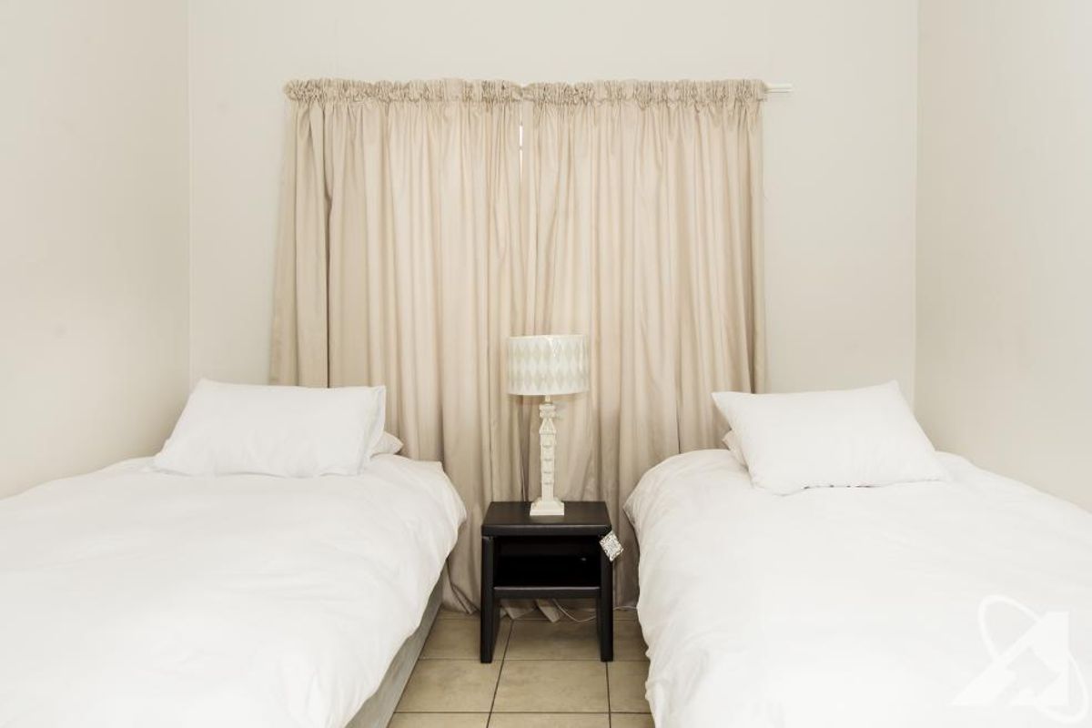 A bedroom featuring tiled flooring and neutral wall finishes, providing a functional space for sleeping arrangements.