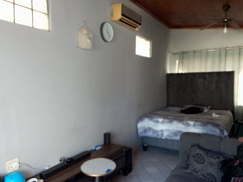 A bedroom featuring tiled flooring, a timber ceiling, a ceiling fan, and a wall-mounted air conditioning unit.
