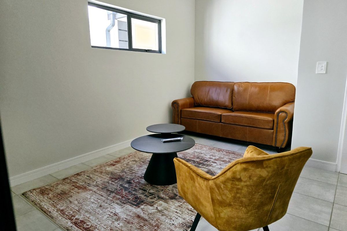 A bright and neutral living room featuring tiled flooring and clean finishes, providing a versatile space for relaxation.