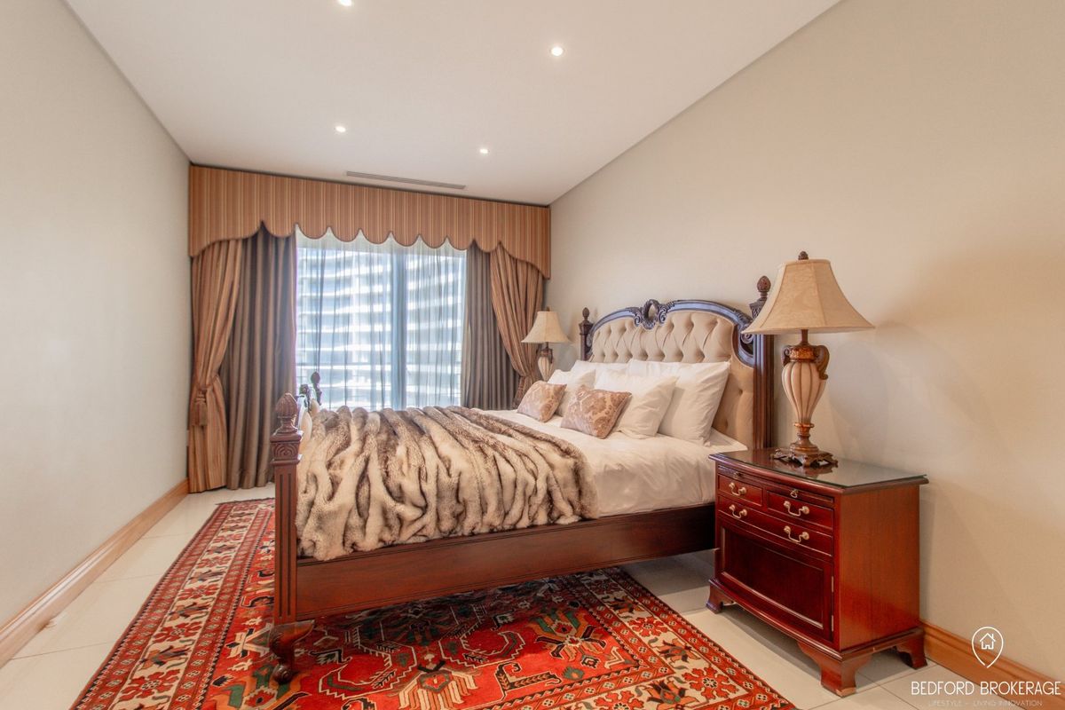 A well-maintained bedroom featuring tiled flooring, recessed downlighting, and integrated ducted air conditioning, offering a clean and neutral living space.