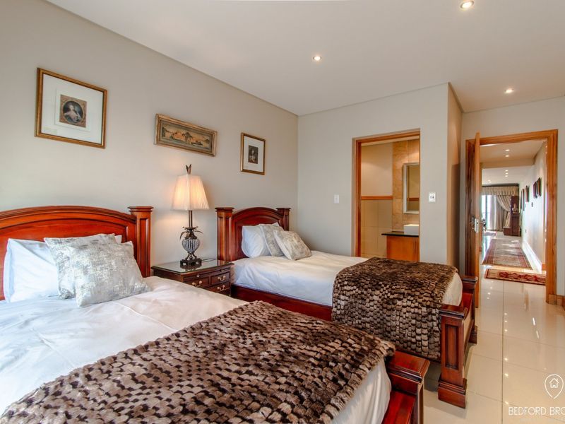 A well-maintained bedroom featuring tiled flooring, recessed lighting, and direct access to an en-suite bathroom.