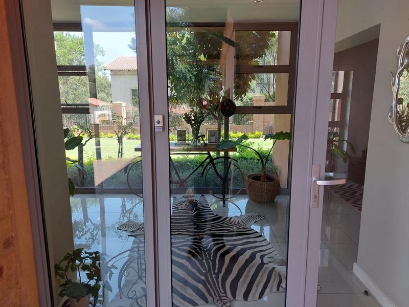 Bright entrance area featuring modern aluminium sliding doors providing direct access to the garden and tiled flooring throughout.