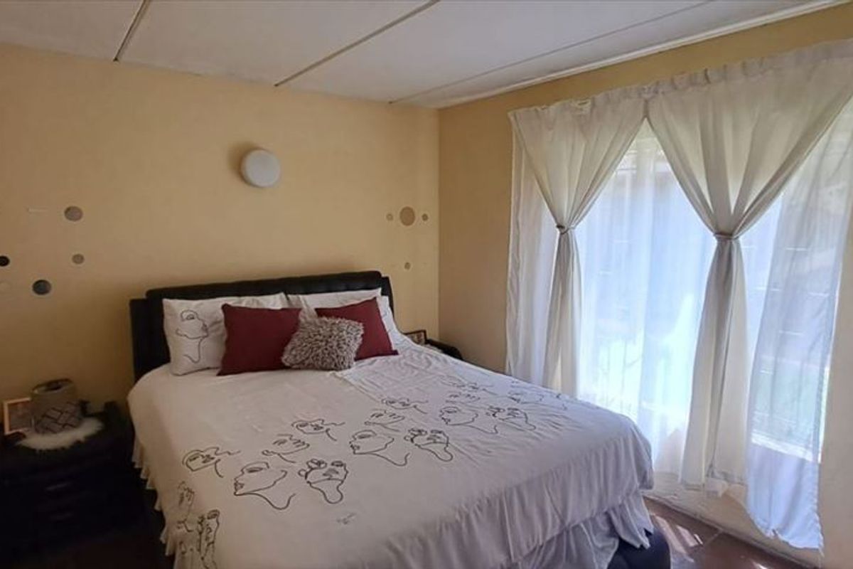 A standard bedroom featuring neutral wall finishes and a window with natural light.