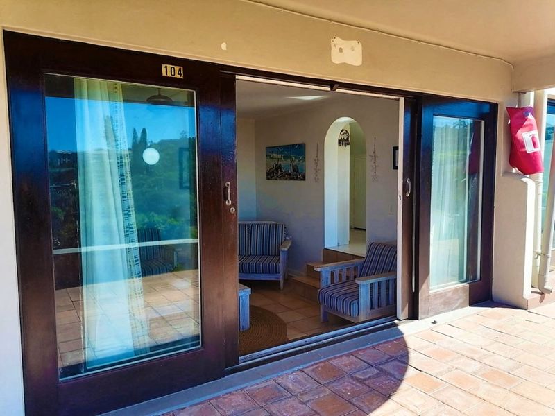 A covered patio area featuring tiled flooring and large sliding glass doors providing access to the interior living space.