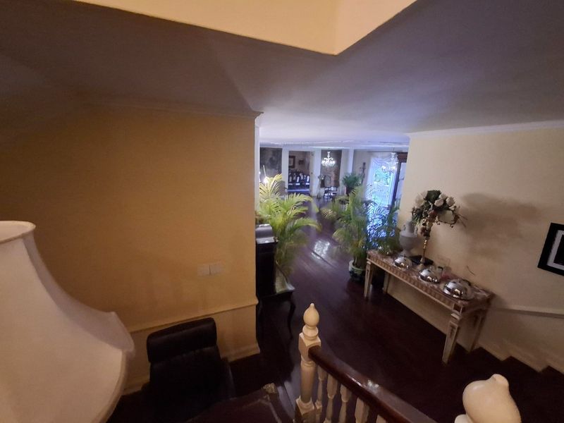 A view from the staircase looking down into a spacious hallway with timber flooring and traditional architectural detailing.