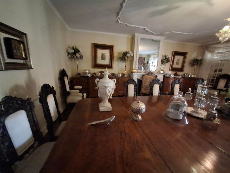 A formal dining room featuring a traditional fireplace with a mantelpiece and decorative ceiling molding, providing a classic and elegant atmosphere.