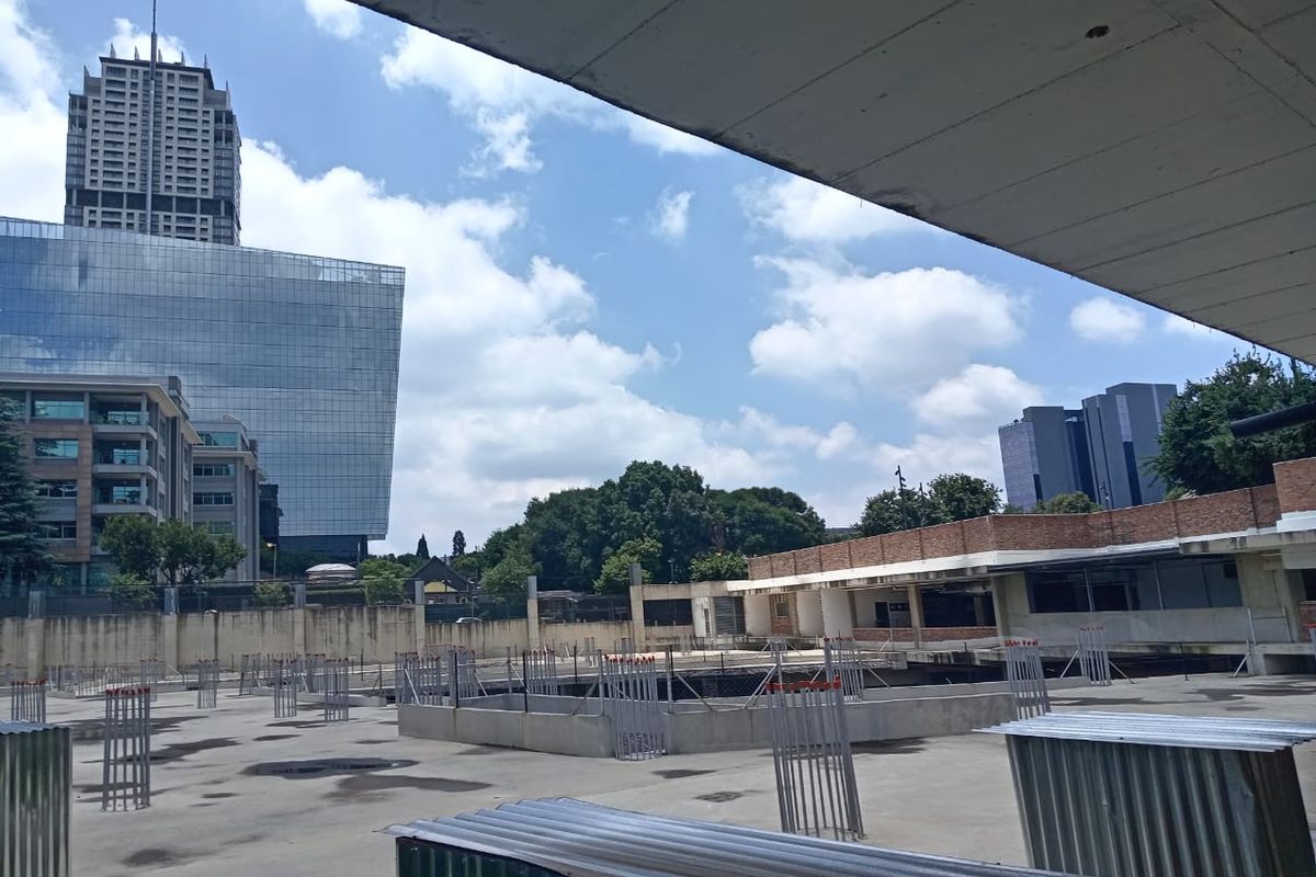 An elevated view of a vacant residential development site featuring exposed concrete foundations and steel reinforcement bars under construction.