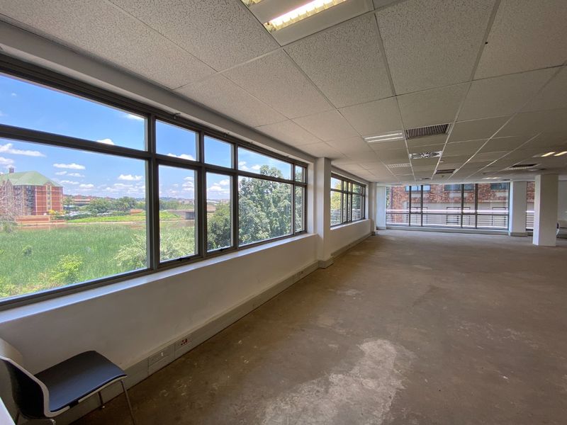 Spacious open-plan office area featuring large windows with natural light, suspended ceilings, and air conditioning, ready for custom fit-out.
