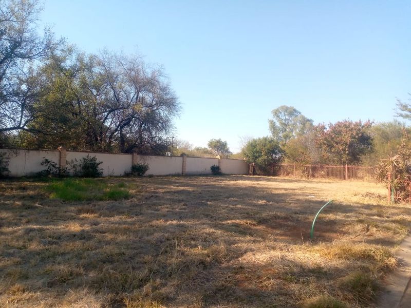A spacious, level residential plot featuring established perimeter walling and metal fencing, offering a blank canvas for future development.