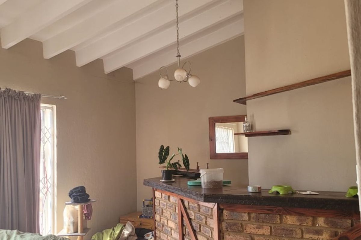 A rustic bar area featuring a brick counter, exposed beam ceiling, and tiled flooring, offering a characterful space for entertaining.