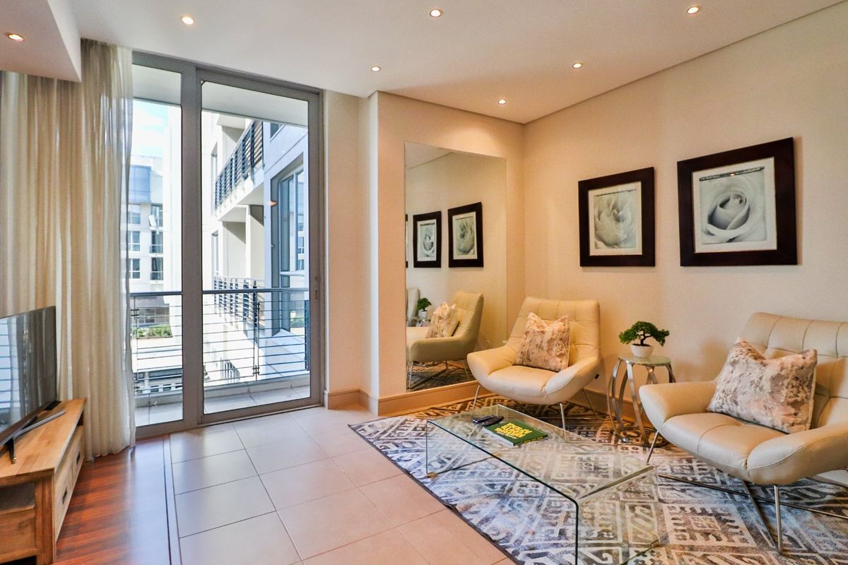 A bright living room featuring tiled flooring, recessed lighting, and a large sliding glass door leading to a balcony.