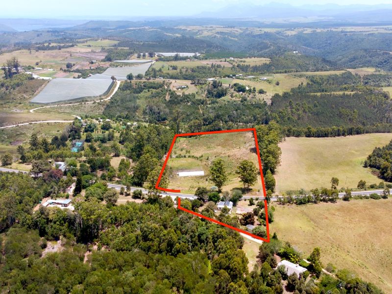 Aerial view of a large farm property with defined boundaries, showcasing the surrounding landscape, access roads, and natural vegetation.