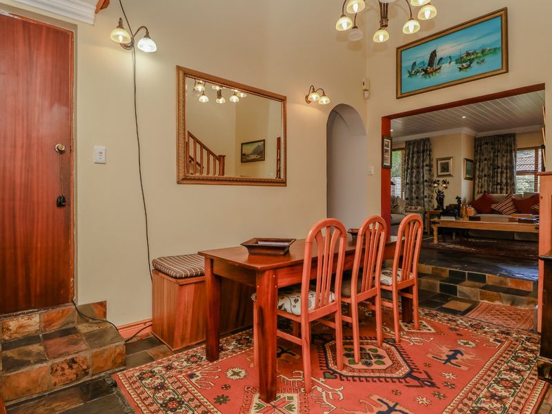 Entrance foyer featuring slate tile flooring, an arched transition to the living area, and a built-in bench, leading to an adjacent staircase.