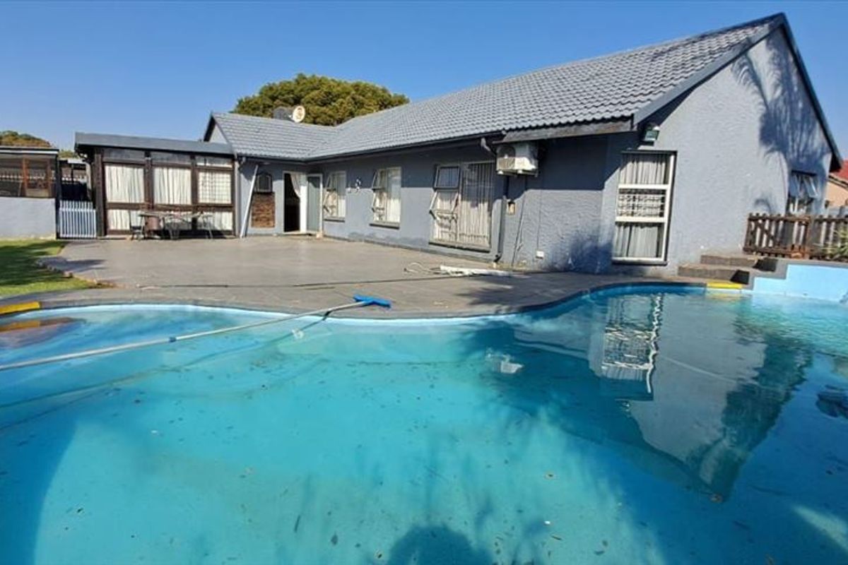 Rear view of the property featuring a swimming pool, paved patio area, and direct access to the main house structure.