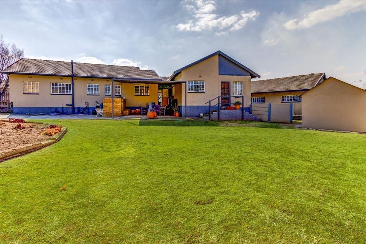 Spacious rear garden featuring a large lawn area, concrete patio, and direct access to the main house structure.
