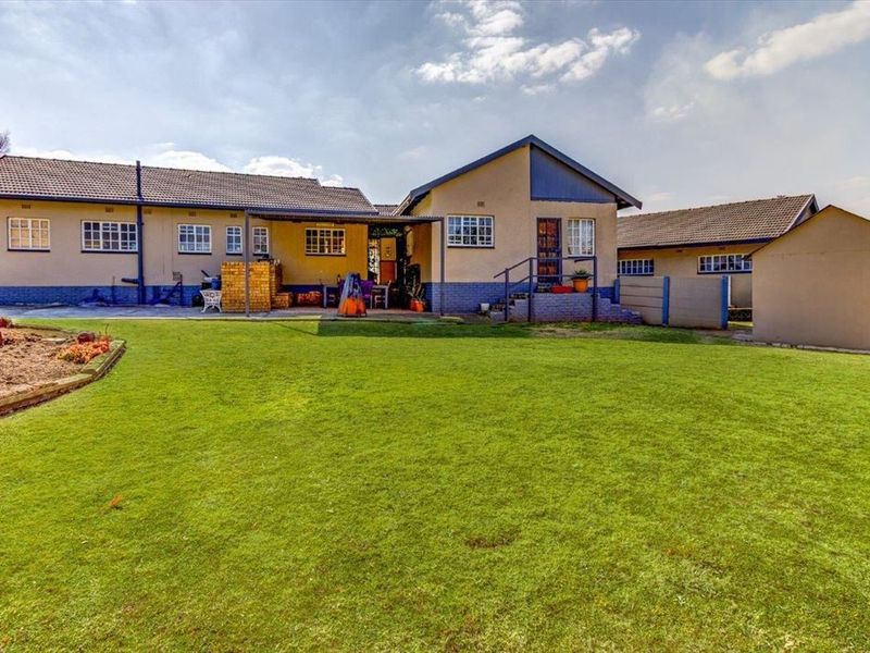 Spacious rear garden featuring a large lawn area, concrete patio, and direct access to the main house structure.