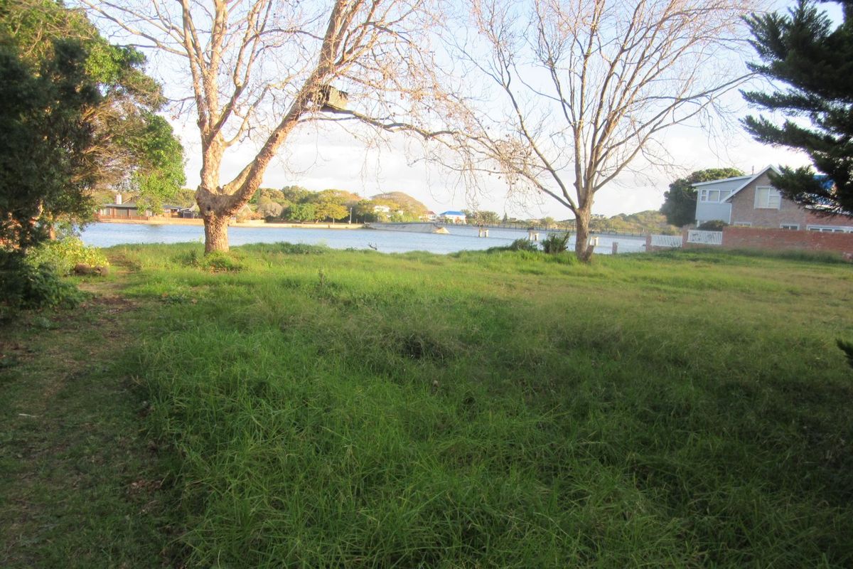 A scenic view of the waterfront from the vacant residential land, featuring mature trees and surrounding neighborhood landscape.