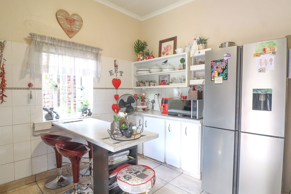 A functional kitchen featuring tiled splashbacks, built-in cabinetry, and a breakfast bar area with tiled flooring.