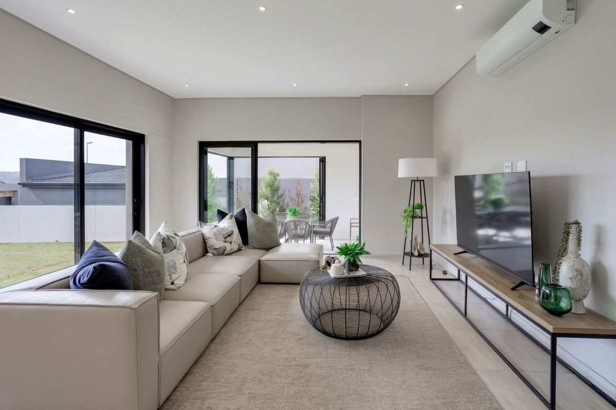 Modern living room featuring tiled floors, recessed lighting, split-system air conditioning, and large aluminium sliding doors providing seamless access to the outdoor patio area.