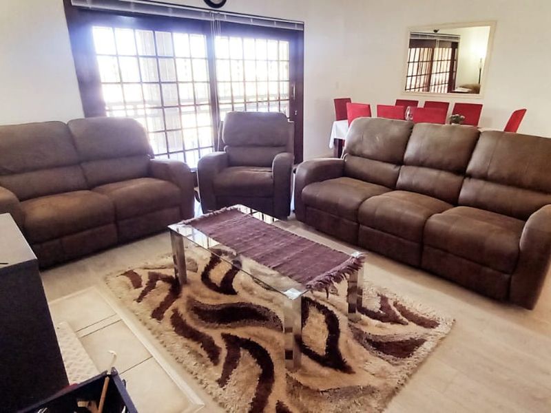 Spacious living room featuring a freestanding fireplace, light laminate flooring, and large sliding glass doors providing access to the outdoor area.