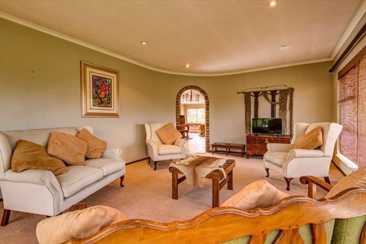 A comfortable living room featuring a distinctive arched doorway leading to an adjacent space, recessed lighting, and neutral wall finishes.