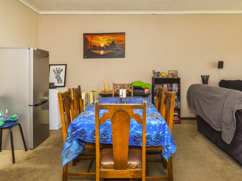 Dining area featuring carpeted flooring and neutral wall finishes, providing a functional space for family meals.