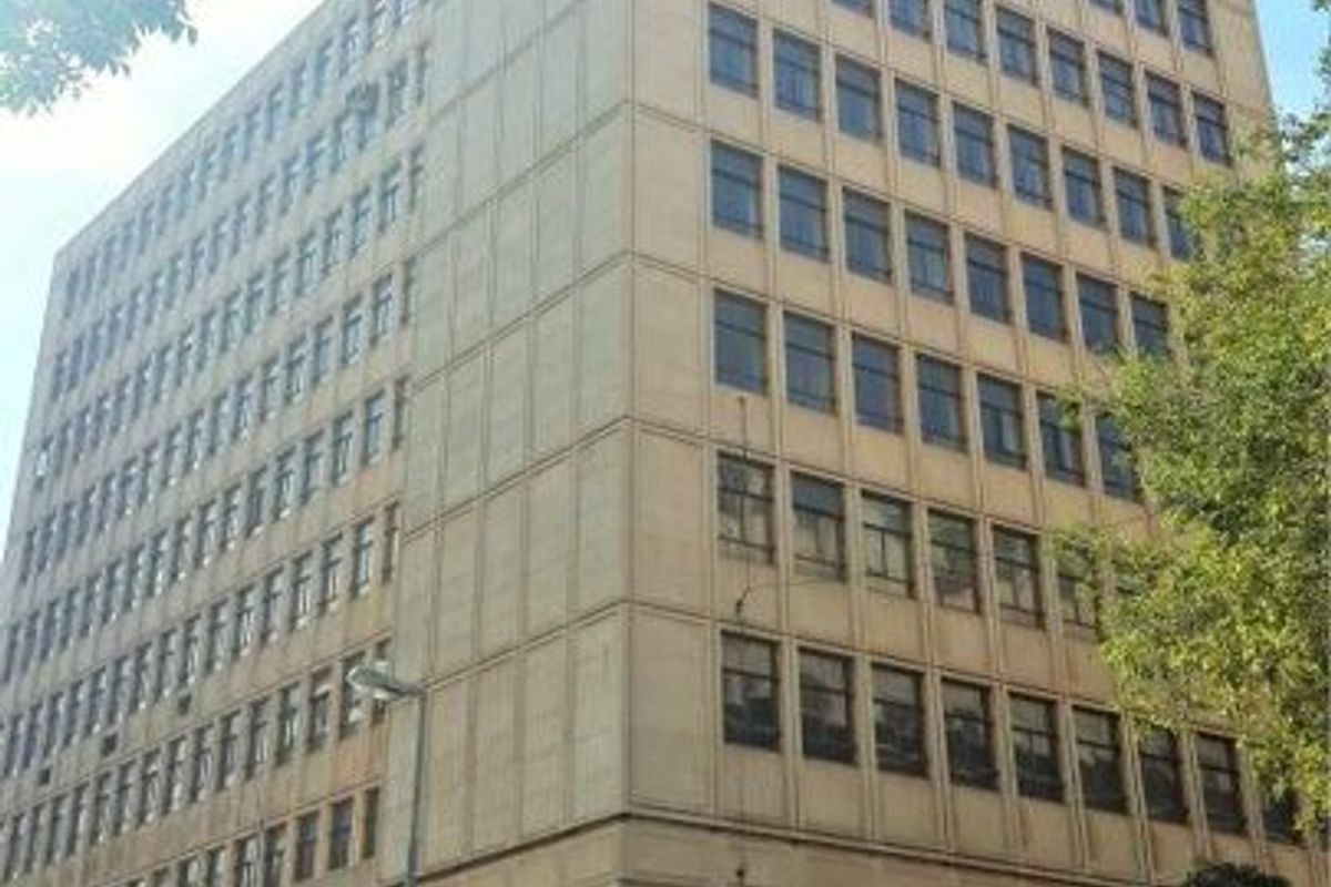 A multi-story commercial building featuring a prominent retail storefront on the ground level with large windows and a structured facade.