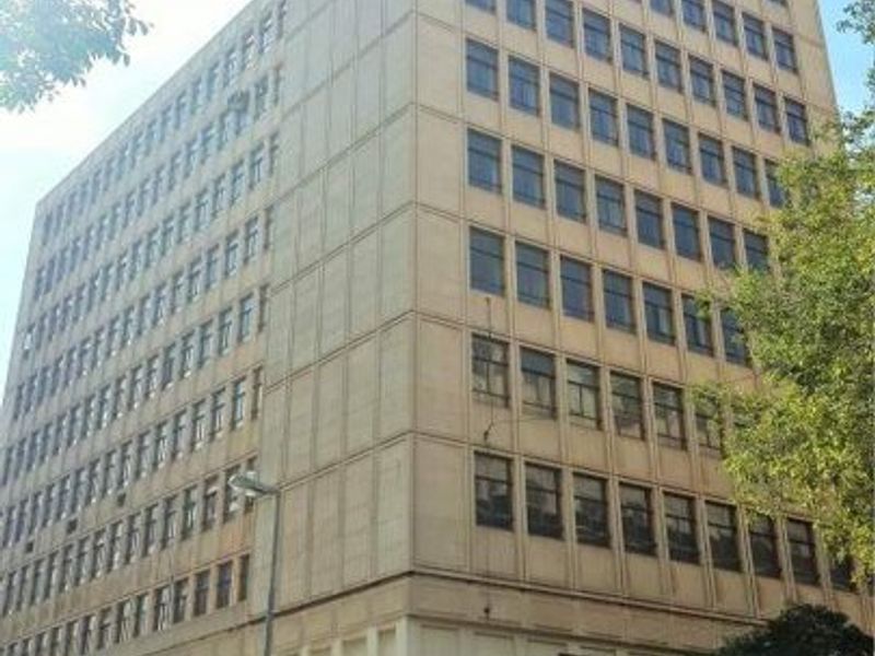 A multi-story commercial building featuring a prominent retail storefront on the ground level with large windows and a structured facade.